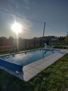 a swimming pool with a chair and the sun at Depto Muy Patagónico, lindo y cómodo in Trelew