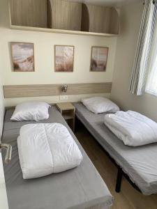 two beds in a room with two pillows at Les pieds dans l'eau in Le Portel