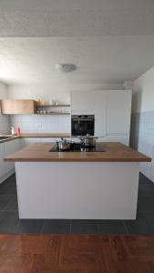 Una cocina con gabinetes blancos y una encimera de madera. en Stylish Apartment with Pool access, en Oklaji