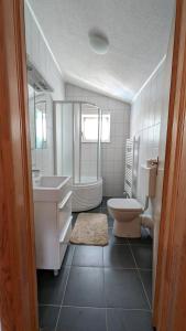 Un baño con bañera, inodoro y lavabo. en Stylish Apartment with Pool access, en Oklaji 12 fotos más