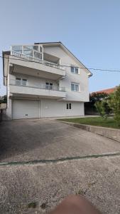 una gran casa blanca con una entrada delante de ella en Stylish Apartment with Pool access, en Oklaji