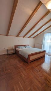 Una cama grande en una habitación con suelo de madera. en Stylish Apartment with Pool access, en Oklaji