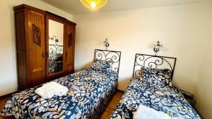a bedroom with two beds and a mirror at Maison sur la Route du Mont Ventoux in Bédoin