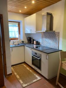 a kitchen with white cabinets and black counter tops at Modernes Apartment in historischem Gebäude in Horb am Neckar
