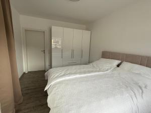 a bedroom with a large bed with white sheets at Ferienwohnung am Schlosspark in Altmünster