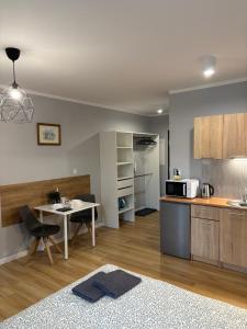 a kitchen and dining room with a table and a microwave at Holdek Apartamenty Ceglana in Katowice