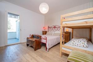 ein Schlafzimmer mit einem Bett und einem Etagenbett mit einer Leiter in der Unterkunft La Casina Bianca in Santa Maria degli Angeli