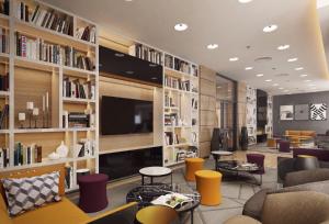 a library with couches and chairs and a tv at Premier Sofia Airport Hotel in Sofia