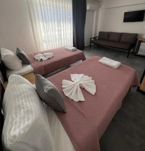 a hotel room with two beds with napkins on them at The Pera Hotel Marmaris in Marmaris