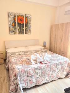 a bedroom with a bed with two paintings on the wall at Bella Taormina in Taormina