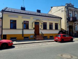 a red car parked in front of a building at Dom Kopernica 3 in Chełm