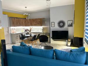 a living room with a blue couch and a table at eliTe deluxe 4 skyview in Kavála