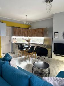 a living room with a blue couch and a table at eliTe deluxe 4 skyview in Kavála