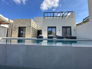 a house with a swimming pool in front of a house at Villa SAMBA in Kamilari