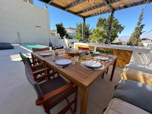 a wooden table and chairs on a patio at Villa SAMBA in Kamilari