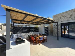 a pavilion with a table and chairs on a patio at Villa SAMBA in Kamilari