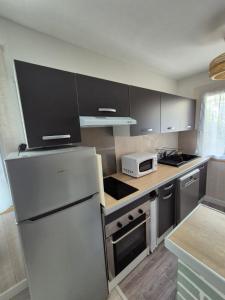 a kitchen with a refrigerator and a microwave at Bel appartement proche de Paris in Puteaux