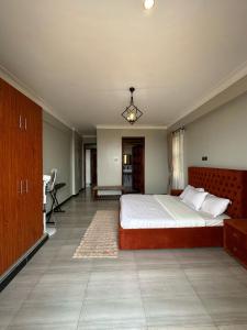 a bedroom with a large bed and a desk at CasaComfy Bukoto in Kampala