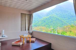 a room with a table and a large window at Courier Station in Wulai
