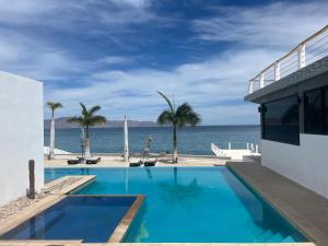 a swimming pool with a view of the ocean at Casa Termales Solo Adultos Frente al Mar Sistema Solar in El Sargento +39 photos
