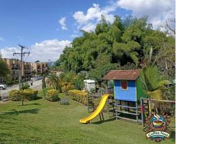 un parque infantil con tobogán y una casa en Coffee Nest - La Tebaida - Armenia - Quindio, en La Tebaida