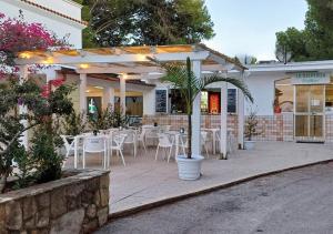 a restaurant with white tables and chairs in front of it at Ostuni Torre Pozzelle Open Air in Ostuni Costa Merlata