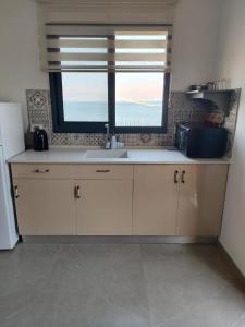 a kitchen with a sink and a window at מול ים המלח זוהר במדבר in Neve Zohar +10 photos