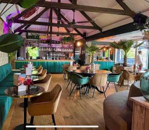 a restaurant with tables and chairs and a bar at Tiny House 76 Leekstermeer in Matsloot