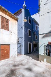 a blue and white building with a garage at APARTMANI EMA in Zadar