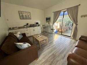 a living room with a couch and a table at Westshore Garden Escape in Victoria