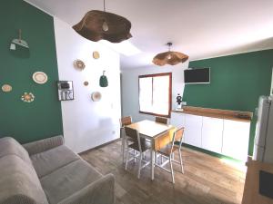 a living room with a couch and a table and a kitchen at L'Aarona du Lidon in Saint-Hilaire-la-Palud