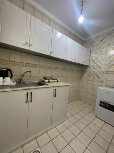 a kitchen with white cabinets and a sink at وحدات سكنية مفروشة in Jeddah