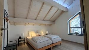 a bedroom with a bed and a large window at Le Chalet du Haut du Bout in Fraize