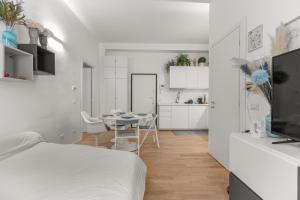 ein Schlafzimmer mit Bett und Tisch und eine Küche in der Unterkunft Casa San Siro-Stadio - Stadio e Metropolitana in Mailand