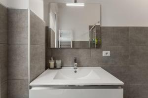 ein Badezimmer mit einem weißen Waschbecken und einem Spiegel in der Unterkunft Casa San Siro-Stadio - Stadio e Metropolitana in Mailand + 22 Fotos