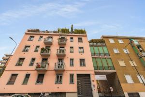 ein rosafarbenes Gebäude mit Pflanzen oben drauf in der Unterkunft Casa San Siro-Stadio - Stadio e Metropolitana in Mailand