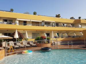 un hotel con piscina frente a un edificio en Fañabé Paradise - Artistically Designed Apartment, en Adeje