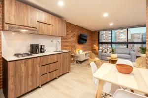 a kitchen and living room with a couch and a table at Kyux Studios by MOME in Medellín