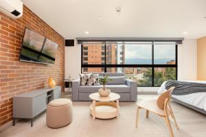 a bedroom with a bed and a brick wall at Kyux Studios by MOME in Medellín