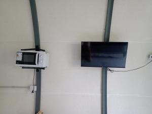 a tv and a microwave hanging on a wall at Tiny house in Bahía Blanca