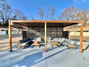 a gazebo with couches and tables in a parking lot at Far Out Motel in Starkville