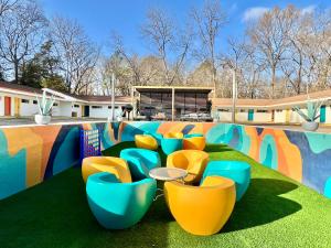 a group of blue and yellow chairs on the grass at Far Out Motel in Starkville +18 photos