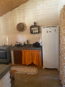 eine Küche mit einem weißen Kühlschrank und einem Herd in der Unterkunft Vila Mangueira in Cavalcante