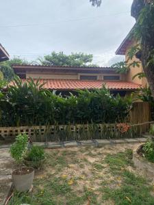 ein Zaun vor einem Haus mit Pflanzen in der Unterkunft Vila Mangueira in Cavalcante