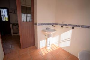 a bathroom with a white sink and a door at Casa Rural Manuel Sevillano in Bornos +48 photos