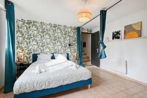 1 dormitorio con cama azul y mural en la pared en EDEN l Jardin, Bbq, Duplex l Parking Gratuit & Super Wifi l Vue Panoramique Sainte-Victoire, en Aix-en-Provence