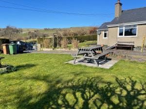 eine Picknickbank auf dem Rasen im Hof in der Unterkunft tabor lane Dolwar our little cottage in Criccieth