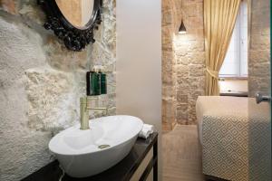 a bathroom with a white sink and a bed at Design rooms ANIMA MUNDI CityCentre right next to Diocletian's Palace in Split +38 photos