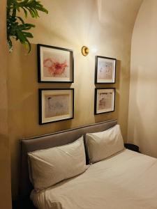 a bedroom with a bed with three pictures on the wall at ANTICA DIMORA Old Town in Molfetta