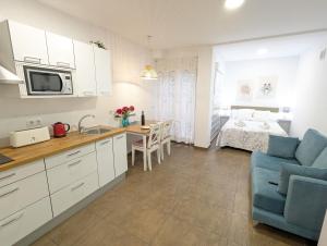 uma cozinha e sala de estar com um sofá e uma cama em Estudios en la playa em Valência